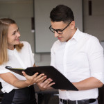 smiling-businesswoman-showing-folder-with-document-businessman-min.jpg