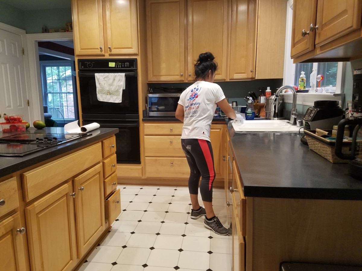 A professional maid from Cimara Cleaning Services dusting a cozy living room in Silver Spring, MD.