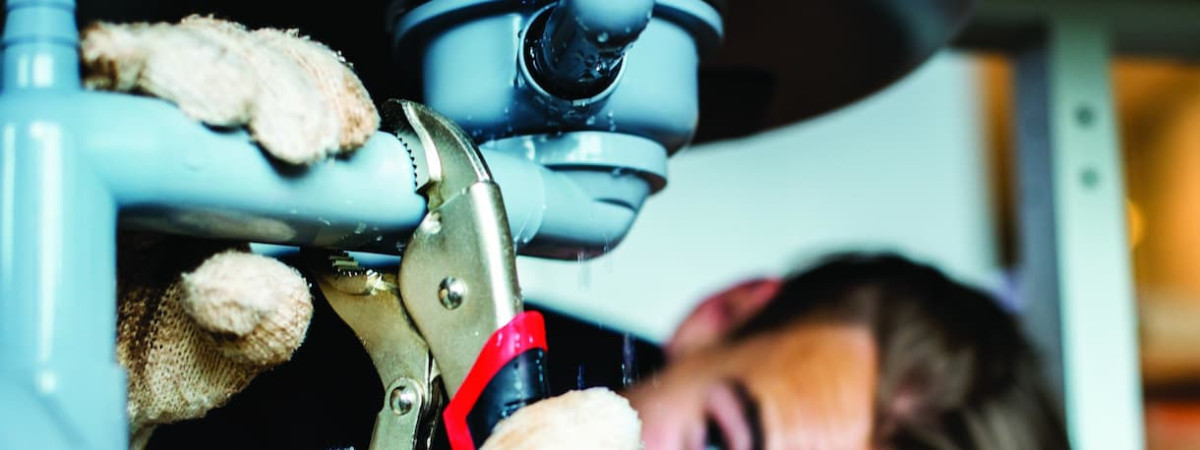 plumber working on a drain pipe