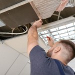 Male Technician Repairing Air Conditioner Indoors.jpg