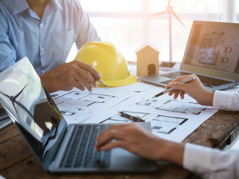 Contractors reviewing project plans and reports to understand the cost of fractional CFO services