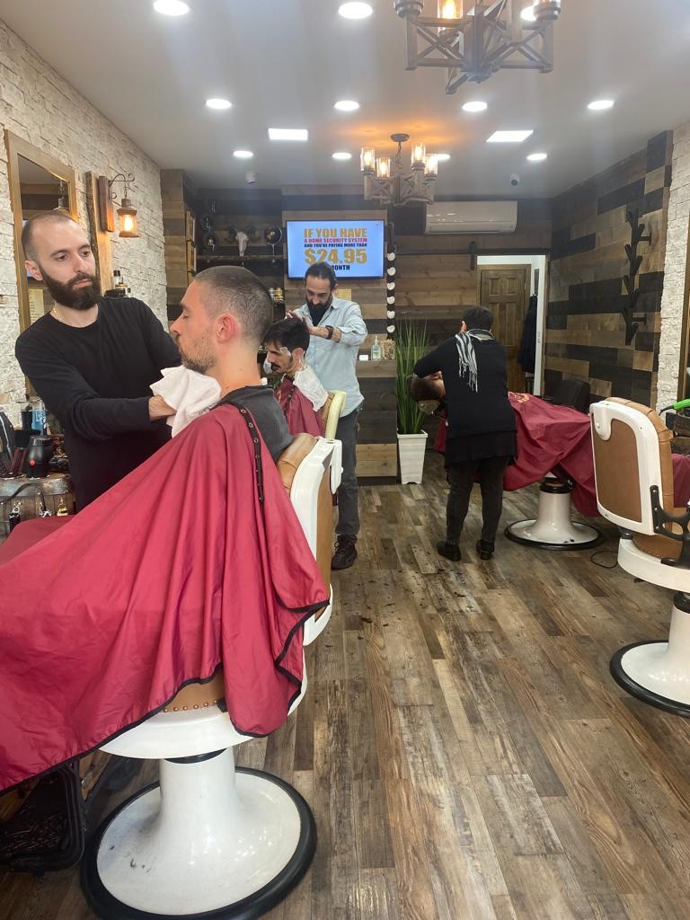 professional barber cutting and styling a client's hair inside a barbershop