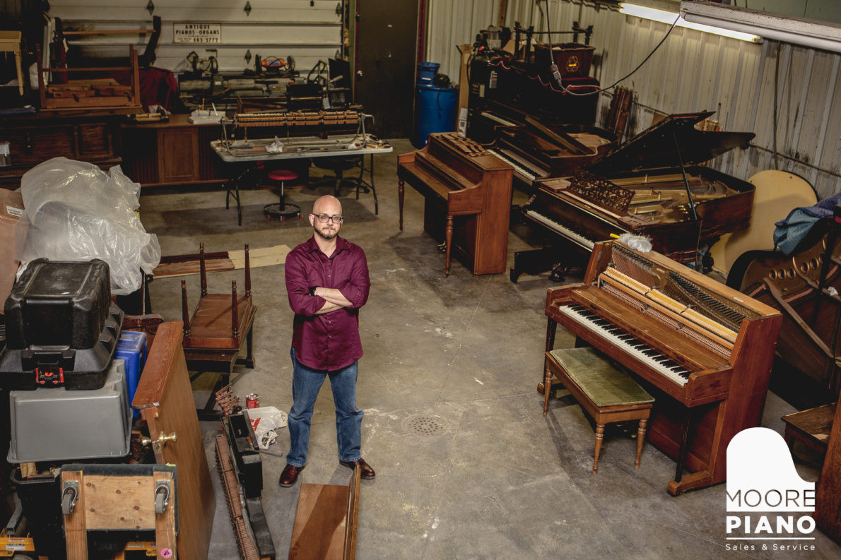 Professional piano technician performing repair on upright piano in Columbia City, Indiana