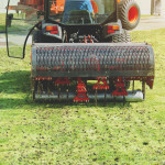 Gardener Operating Soil Aeration Machine on Grass Lawn.jpg