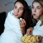 image of 2 girls watching a streaming service and eating popcorn.png