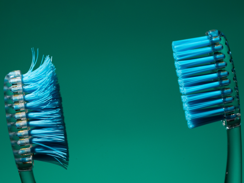  Comparison of a worn toothbrush with frayed bristles next to a new toothbrush, showing why replacing your toothbrush every three to four months matters for effective cleaning