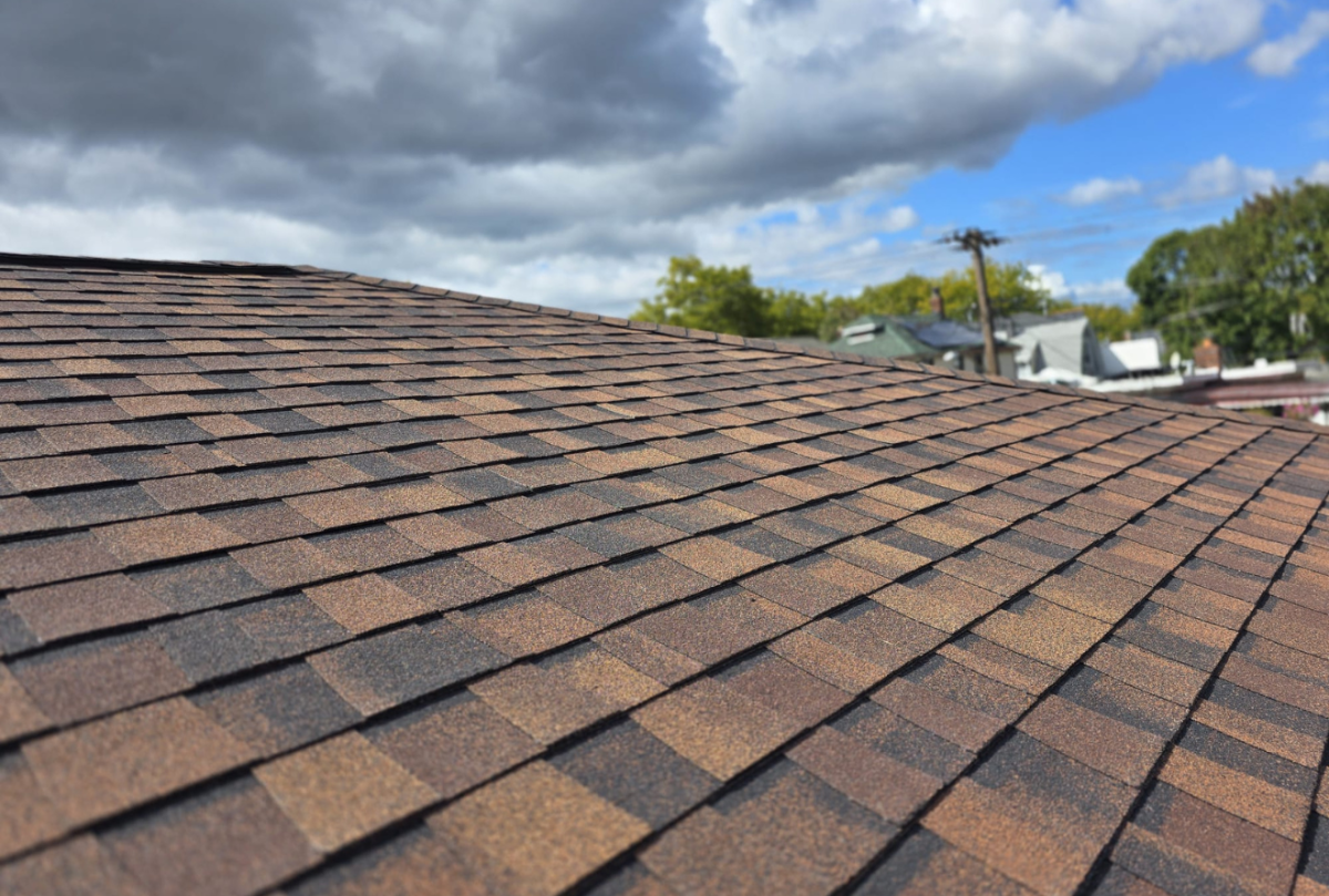 Roof replacement in Queens and the Bronx – Elite Homes of NY installing new asphalt shingles on a residential home.