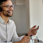 happy-call-center-agent-using-computer-while-communicating-with-clients-working-office.jpg