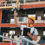 holding-notepad-with-plan-young-man-working-uniform-construction-daytime-min.jpg