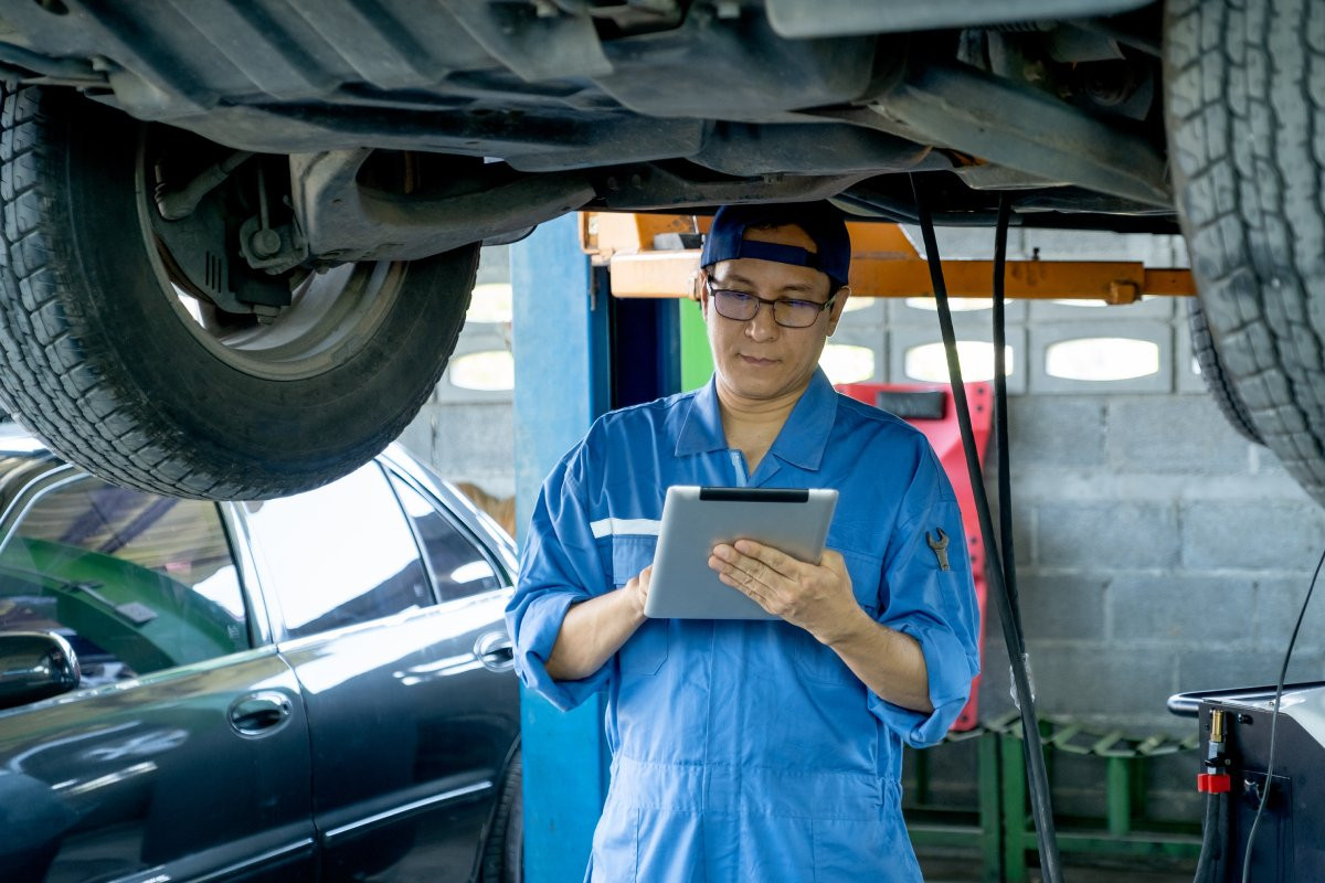 automotive mechanic inspecting car 