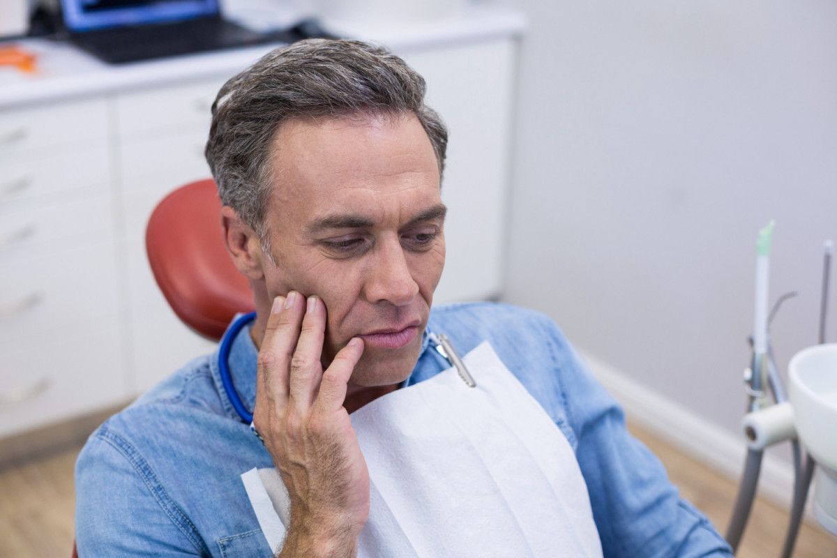 man with dental emergency in a dentist's chair