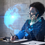 businesswoman-speaks-phone-world-map-hologram-double-exposure-min.jpg