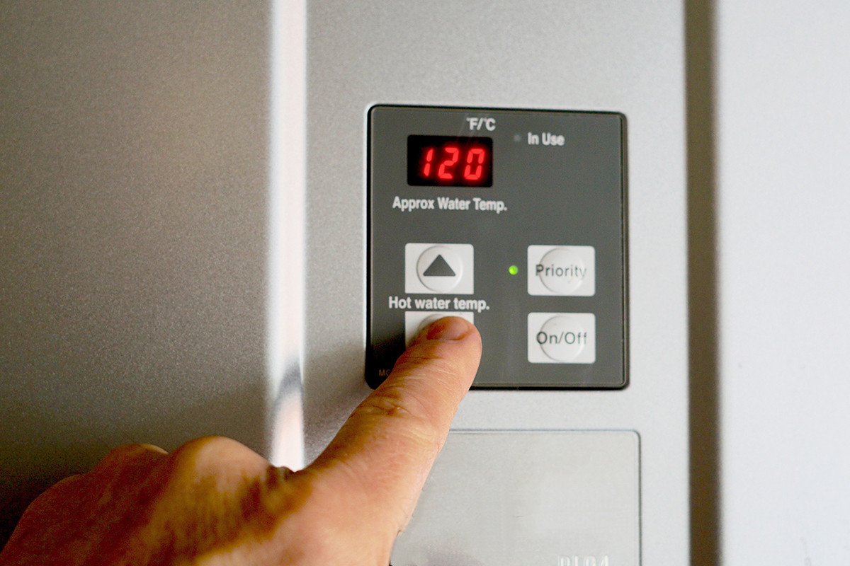 Finger on Water Heater temperature button 