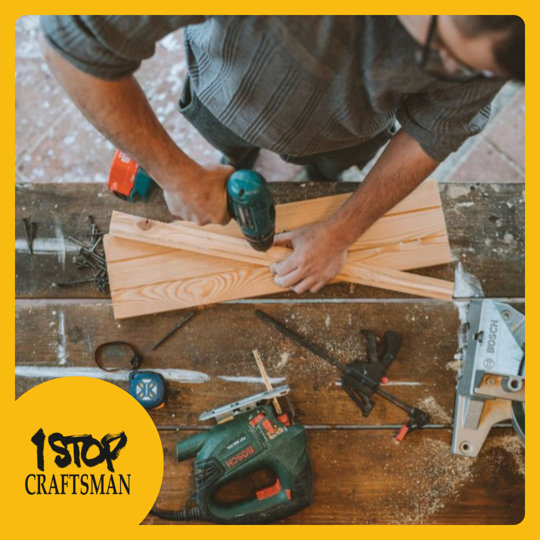 handyman using a power drill on wooden planks at a cluttered workbench