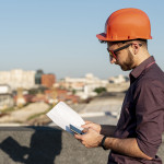 man-standing-rooftop-with-phone-hand-min.jpg