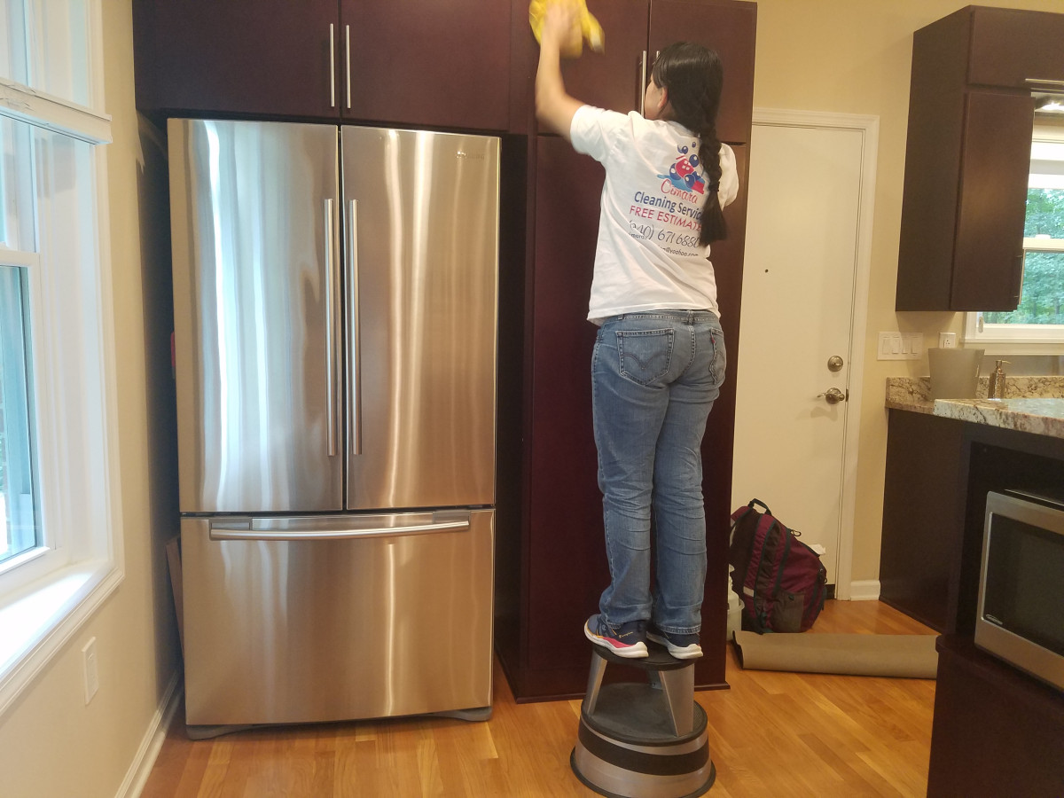 A professional cleaning service deep cleaning a kitchen in Alexandria, VA.
